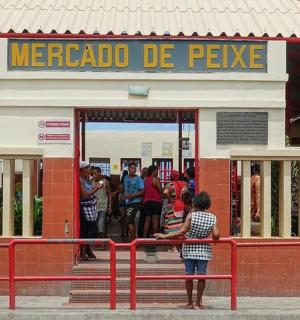 一个小女孩站在火车站前的红色长椅上