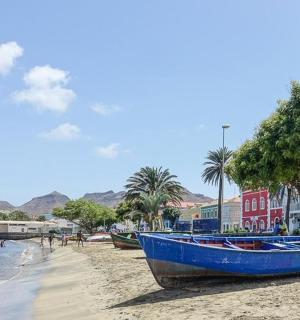 一艘蓝色的小船停在水边的沙滩上