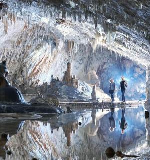 两个人穿过白雪覆盖的洞穴