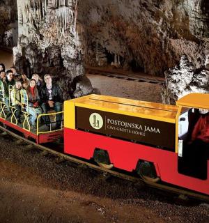 skupina lidí jedoucí v miniaturním vláčku