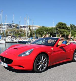 一名男子和一名儿童坐在一辆红色汽车里