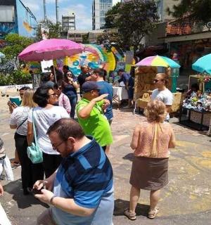 a crowd of people standing in a street with umbrellas