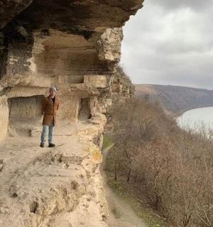 seorang pria berdiri di sisi tebing