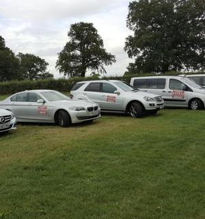 skupina aut zaparkovaných na poli