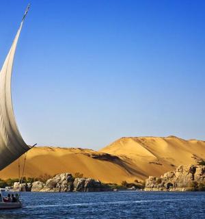 a boat with a large sail in a body of water