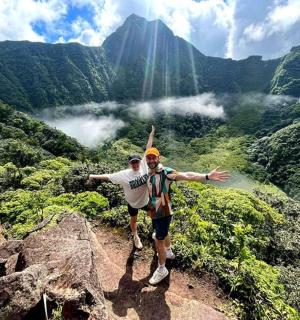 tveir menn standa á fjallstindi