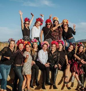 skupina žen pózujících pro fotografii na pláži