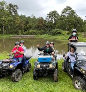 a group of people standing on atvs
