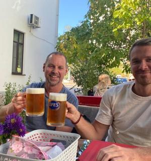 رجلان يجلسان على طاولة وبيدهما كؤوس من البيرة