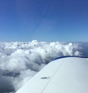 vaizdas į virš debesų skrendančio lėktuvo sparną