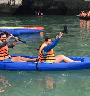 three people in a blue kayak in the water