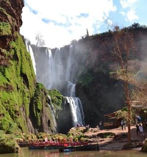 a group of people standing in front of a waterfall