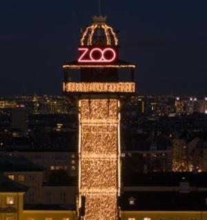 a lit up tower with a clock on top of it