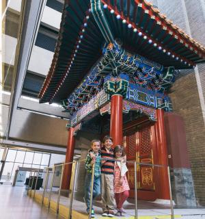 two children standing in front of a sign in a building
