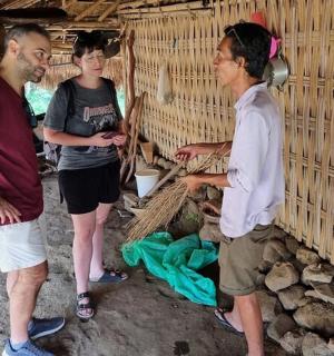 a group of three people standing in a hut