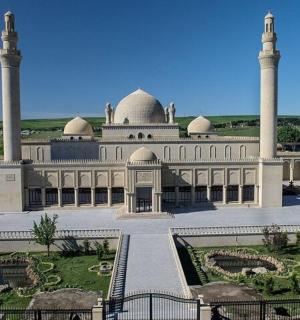 a large building with two large domes and a courtyard