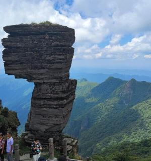 一群人站在岩石塔顶上