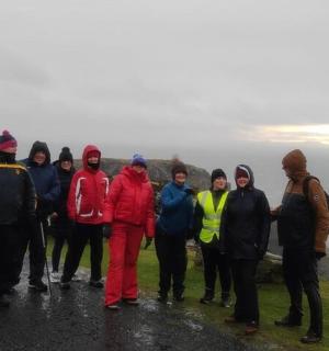 skupina lidí stojících na okraji útesu