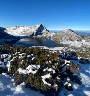 an aerial view of a snow covered mountain with a lake