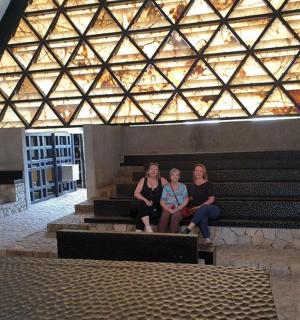 three women sitting on stairs in front of a building