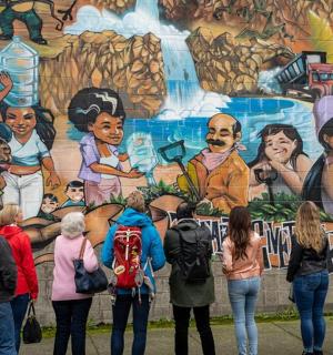 a group of people standing in front of a mural