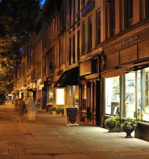 a street at night with people walking down the street