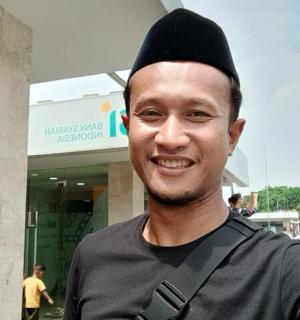 bir binanın önünde duran siyah şapkalı bir adam