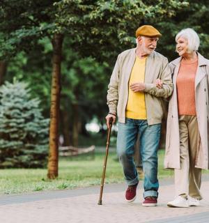 一对老年男女拄着拐杖在人行道上行走