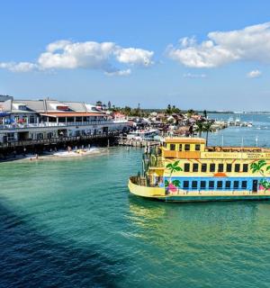 a yellow boat in the water next to a pier