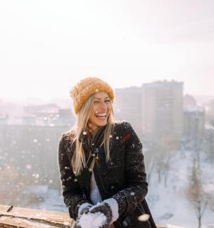 žena sedící na římse ve sněhu