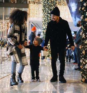 一家人带着圣诞树穿过商场