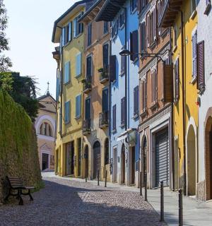 an empty street with colorful buildings and a bench