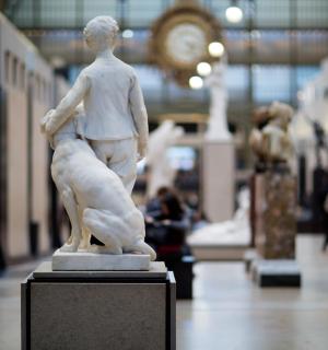 a statue of a man with a dog in a museum