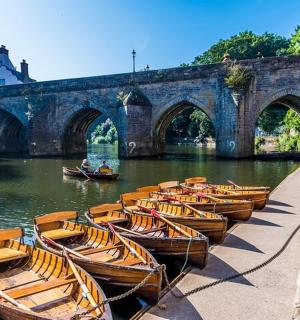 a group of boats parked in the water near a bridge