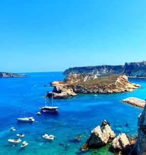 a group of boats in the water near a cliff