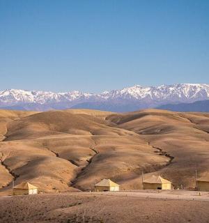 a desert with houses and mountains in the background