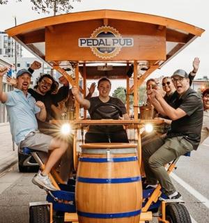 a group of men riding on a beer barrel pulled by a beer barrelokedoked