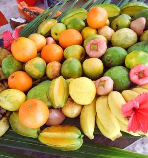 a pile of fruit on a table with bananas and oranges