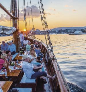 一群人坐在船上的桌子旁