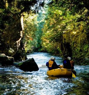dva lidé na voru v řece