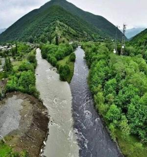 an aerial view of a river next to a road