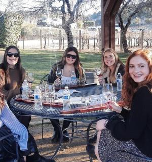 skupina žen sedících kolem stolu