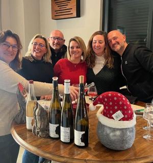a group of people standing around a table with wine bottles