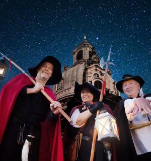 three people dressed in costumes standing in front of a building