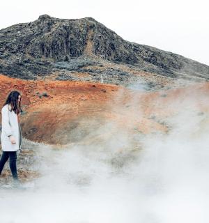 a woman walking in front of a mountain