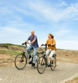 一男一女骑着自行车在路上行驶
