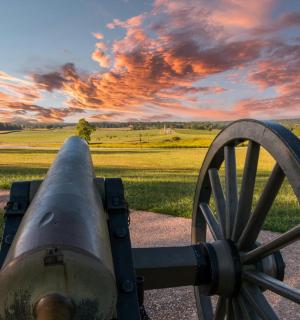 a cannon with a sunset in the background