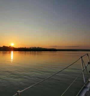 a boat on the water with the sunset in the background