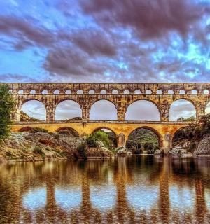 a bridge over a river with reflections in the water