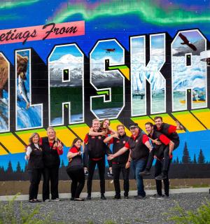 a group of people standing in front of a mural